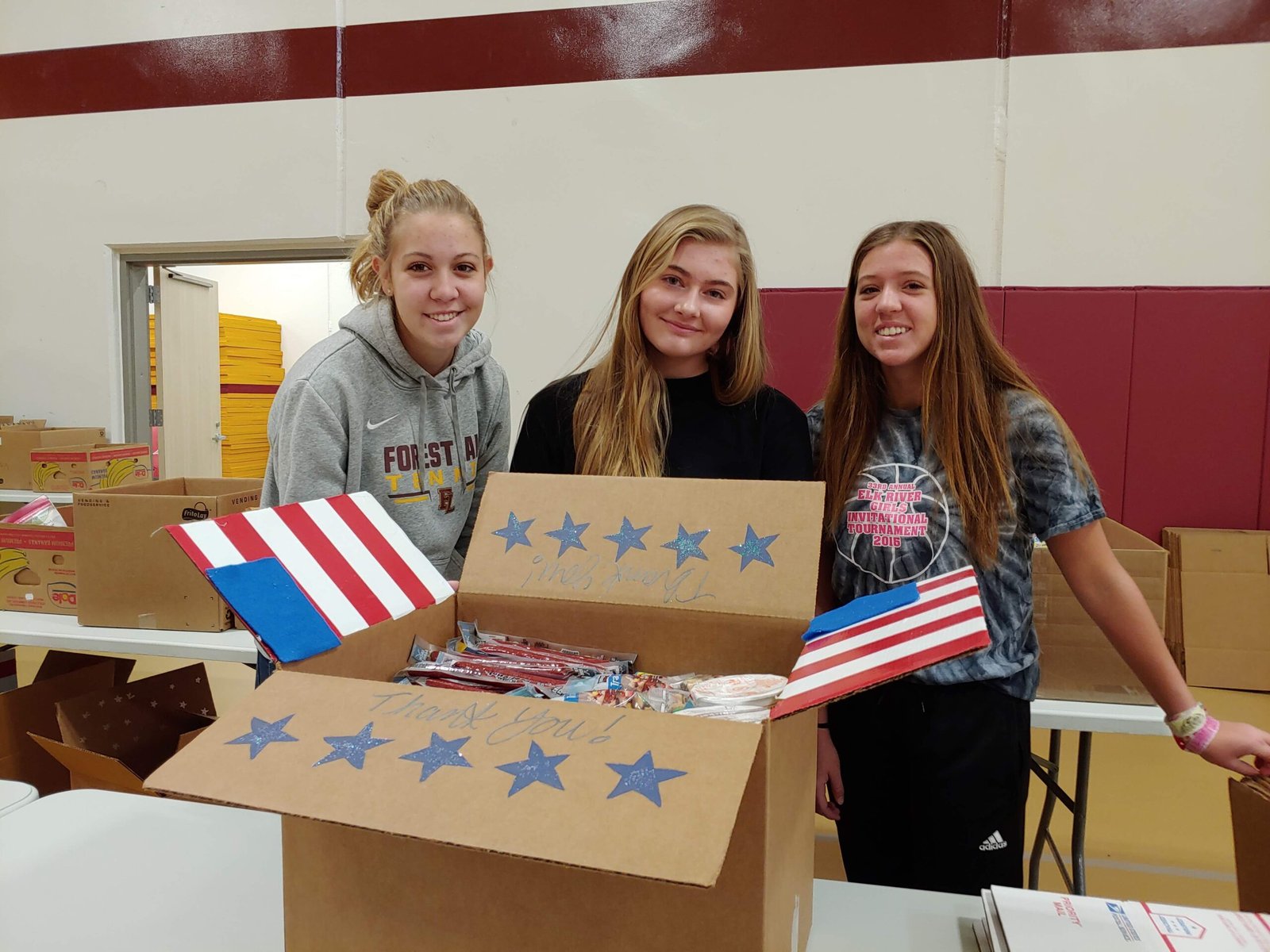 Group of women packing military care packages, focusing on reducing the cost of sending supplies to troops.