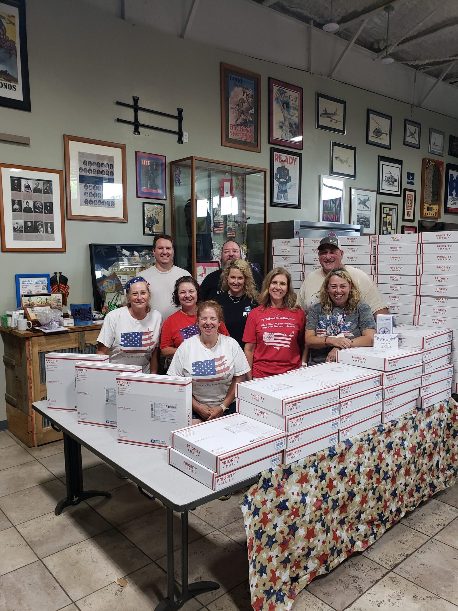 volunteers with hundreds of packed care packages ready to send to military